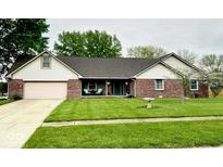 Charming brick ranch home with a well-manicured lawn and inviting covered front porch at 1934 Constitution St, Greenfield, IN 46140