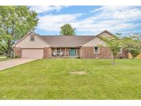 Charming brick home featuring a well-manicured lawn and a delightful covered front porch at 1934 Constitution St, Greenfield, IN 46140