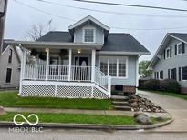 Charming two-story home featuring a covered front porch with white railings and meticulous landscaping at 223 E Fordice St, Lebanon, IN 46052
