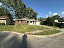 Charming single-story brick home with a well-manicured lawn and attached garage at 2453 Larnie Ln, Indianapolis, IN 46219