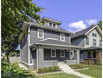 Charming two-story home with gray siding, white trim, a welcoming front porch, and well-manicured landscaping at 2940 N Park Ave, Indianapolis, IN 46205