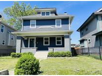 Charming two-story home featuring a covered porch, a well-manicured lawn, and classic architectural details at 2940 N Park Ave, Indianapolis, IN 46205