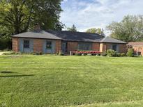 Charming brick home with a well-manicured lawn and flower beds at 3128 W 12Th St, Anderson, IN 46011