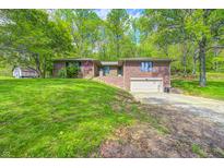 Exterior view of a brick home with an attached garage, situated on a lush lawn at 4080 S London Dr, Martinsville, IN 46151