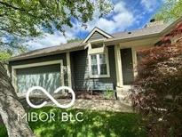 Inviting single story home featuring an attached garage, a well-maintained lawn, and mature trees at 4655 Framington Ct, Indianapolis, IN 46254