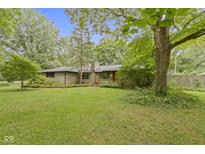 Charming single-story home with a well-maintained lawn and mature trees at 5005 Bonnie Brae St, Indianapolis, IN 46228