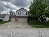 Charming two-story home featuring a large tree, a two-car garage and a well-manicured lawn at 5817 Jamestown Square Ln, Indianapolis, IN 46234