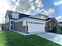 Attractive single-Gathering home featuring a brick facade, white garage door, and well-manicured lawn at 6040 Bluecrest Dr, Brownsburg, IN 46234