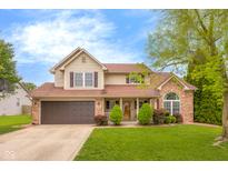 Charming two-story home featuring a well-maintained lawn and inviting front entrance with brick and vinyl siding at 6096 E Conestoga Trl, Columbus, IN 47203