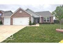 Well-maintained brick home with a two-car garage and a lush green lawn at 728 Jefferson Park Dr, Pittsboro, IN 46167
