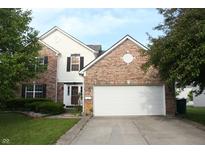 Charming two-story brick home with a two-car garage, a well-maintained lawn, and mature trees at 8551 Walden Trace Dr, Indianapolis, IN 46278