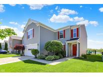 Charming two-story home featuring a well-maintained lawn, red shutters, and an attached garage at 9557 W Lantern Ln, Pendleton, IN 46064