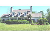 Charming two-story home with dormer windows, a covered front porch and beautifully manicured landscaping at 9909 E Mcgregor Rd, Indianapolis, IN 46259