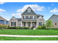 Charming two-story home with brick and stone exterior, lush lawn, and well-manicured landscaping at 11323 Still Creek Dr, Zionsville, IN 46077