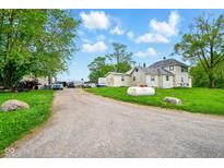 Large lot with a farmhouse style home, propane tank, and a long gravel driveway at 1170 E 400 S, Lebanon, IN 46052