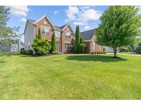 Beautiful two-story brick home with manicured lawn and tasteful landscaping at 13553 Lorenzo Blvd, Carmel, IN 46074