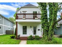 Charming two-story home featuring a balcony, manicured lawn, and tasteful landscaping at 1434 Laurel St, Indianapolis, IN 46203
