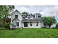 Stunning two-story home featuring a brick exterior, well-manicured lawn, and elegant architectural details at 1536 Copperwood Pl, Carmel, IN 46033
