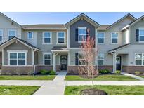 Charming townhome featuring neutral siding, brick accents, and a well-manicured lawn at 17237 Rancorn Pl, Westfield, IN 46074