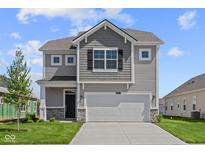 Two-story home featuring a two-car garage, stone accents and gray siding at 1874 Victor Higgins Dr, Shelbyville, IN 46176