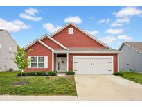 Charming single-story red home with a well-manicured lawn, white trim, and an attached two-car garage at 2006 Monticlair Ln, Columbus, IN 47201