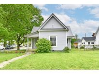 Charming home featuring a metal roof, well-kept lawn, and vibrant green foliage at 2335 Main St, Elwood, IN 46036