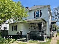 Two-story home showcasing a covered porch and a partially brick facade at 2701 N Gale St, Indianapolis, IN 46218