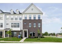 Charming townhouse with brick facade, a black front door, and well-manicured lawn and landscaping at 3279 Morab Dr, Zionsville, IN 46077