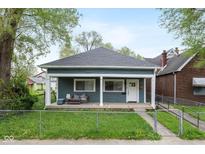 Charming single story home with a cozy front porch and well maintained lawn and landscaping at 33 N Beville Ave, Indianapolis, IN 46201
