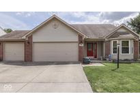 Charming home featuring a three-car garage, brick accents, and a vibrant red front door at 4675 Walker St, Greenwood, IN 46143