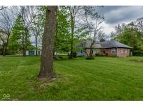 Charming brick home with well-maintained lawn, mature trees and a detached garage, offering serene countryside living at 8944 W 21St St, Indianapolis, IN 46234