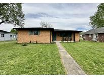 Charming single-story brick home featuring a well-maintained lawn and inviting front walkway at 100 Lincoln St, Plainfield, IN 46168