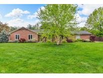 Beautiful brick home with a sprawling green lawn and mature trees offering great curb appeal at 10559 Rolling Springs Dr, Indianapolis, IN 46234