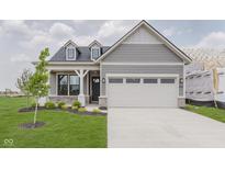 Charming single-Gathering home with gray siding, a two-car garage and a well manicured front yard at 13324 Roundtop Rd, Noblesville, IN 46060