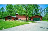 Charming home features a detached garage, well-maintained lawn, mature trees, and inviting curb appeal at 2240 Bill Smith Rd, Martinsville, IN 46151