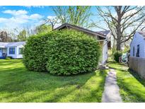 Landscaped front yard with lush green grass and mature shrubbery, adding to the home's curb appeal at 3609 N Keystone Ave, Indianapolis, IN 46218
