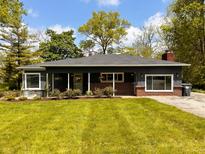 Charming single-story home with well-manicured lawn, mature trees, and a welcoming front porch at 406 Frst Pk N Dr, Greenwood, IN 46142