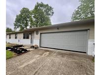Close up of a single-story house with a two-car garage and landscaped front yard at 4718 Tempe Ct, Indianapolis, IN 46241