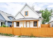 Charming two-story home with a bright yellow fence and inviting front porch at 647 Coffey St, Indianapolis, IN 46221