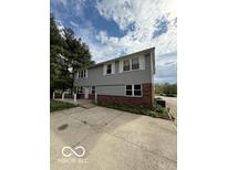 Two-story home with gray siding, large windows, and a brick foundation at 7835 Caswell St, Indianapolis, IN 46259