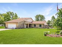 Beautiful stone home with an attached two-car garage and expansive front yard at 8111 Timberwood Dr, Plainfield, IN 46168