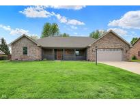 Charming one-story brick home featuring a well-maintained lawn and a covered front porch at 815 Stewart Rd, Anderson, IN 46012