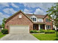Charming brick home featuring a two-car garage, well-manicured lawn, and classic architectural details at 11850 Stepping Stone Dr, Fishers, IN 46037