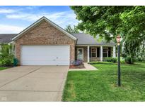 Charming brick home with a well-maintained lawn, attached garage, and inviting front porch at 12257 Driftstone Dr, Fishers, IN 46037