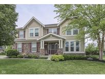 Charming two-story home featuring a stone facade, well-manicured lawn, and inviting front porch at 1476 Anon Ct, Greenwood, IN 46143