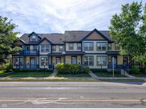 Charming multi-Gathering exterior featuring a light yellow facade and blue accents, complemented by lush greenery and a well-manicured lawn at 2260 Central Ave, Indianapolis, IN 46205