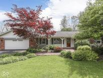 Charming ranch-style home featuring manicured lawn, brick accents, and a bright red front door at 31 N Restin Rd, Greenwood, IN 46142