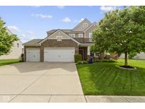 Charming two-story home with a three car garage, brick accents, and well-manicured lawn at 5593 Ralfe Rd, Indianapolis, IN 46234