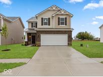 Charming two-story home featuring brick and siding, complemented by a spacious two-car garage and manicured lawn at 564 Plowman Dr, Shelbyville, IN 46176