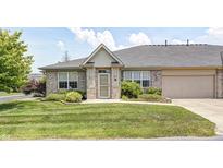 Well-maintained home featuring a brick facade, an attached garage, green lawn, and manicured landscaping at 6816 Park Square Dr # C, Avon, IN 46123